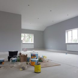 painters equipment in the middle of a freshly painted grey room