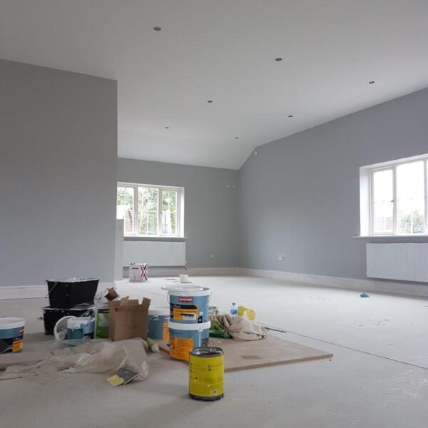 painters equipment in the middle of a freshly painted grey room